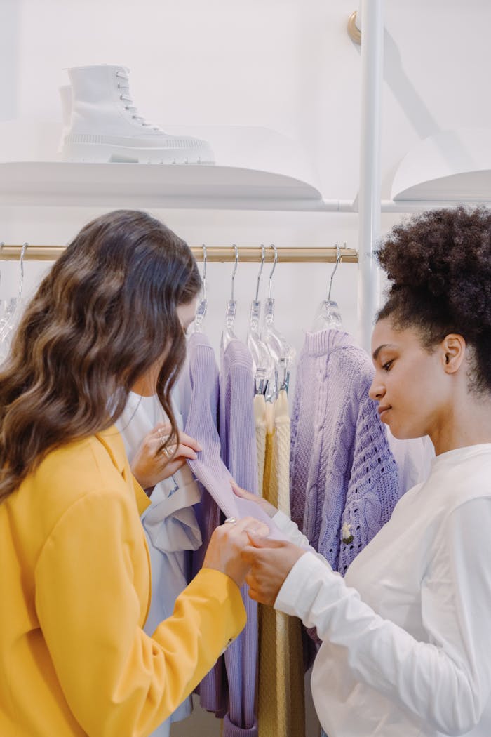 contact-img Two women examining clothes in a stylish clothing store.