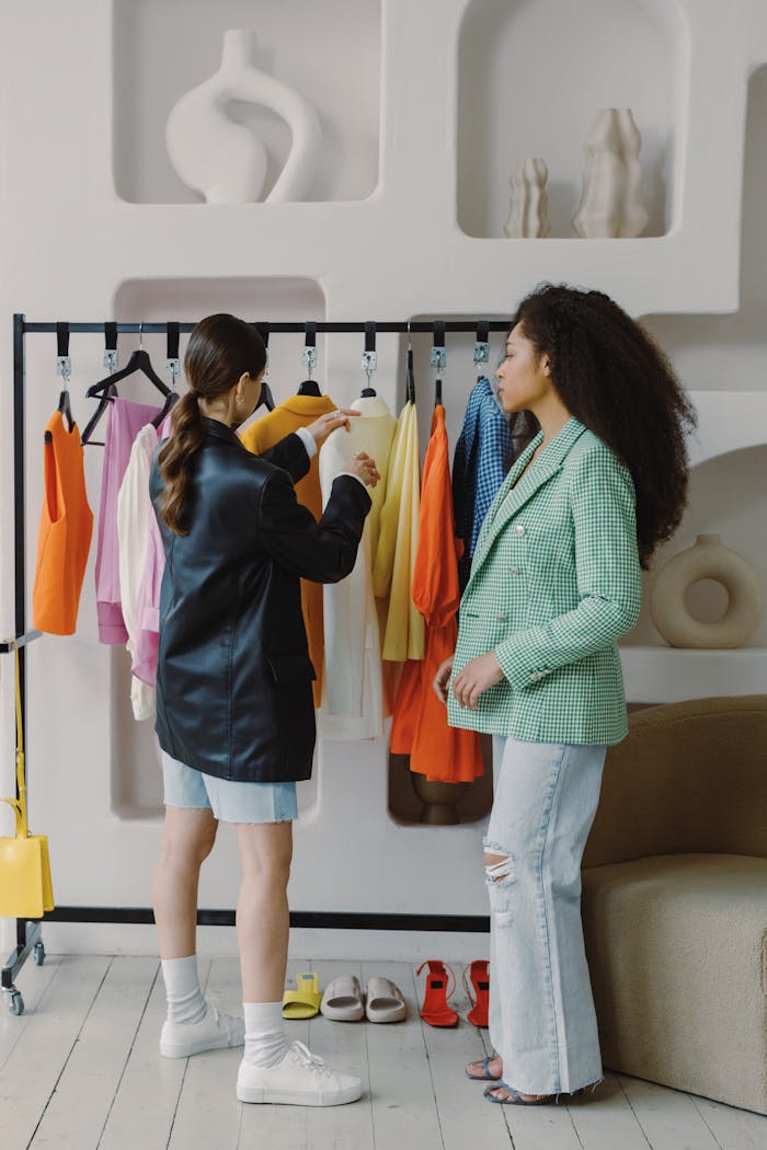 about-01 Two women discussing fashion choices in a stylish, modern room.