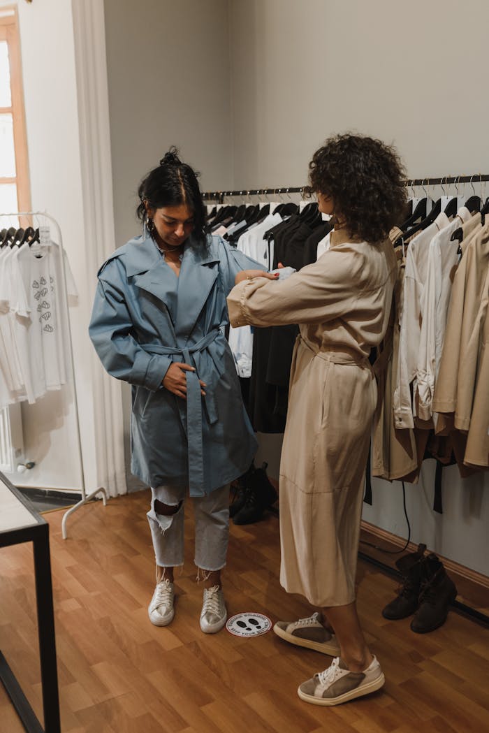 services-02 Two women engaging in fashion shopping, trying on clothes in a boutique.