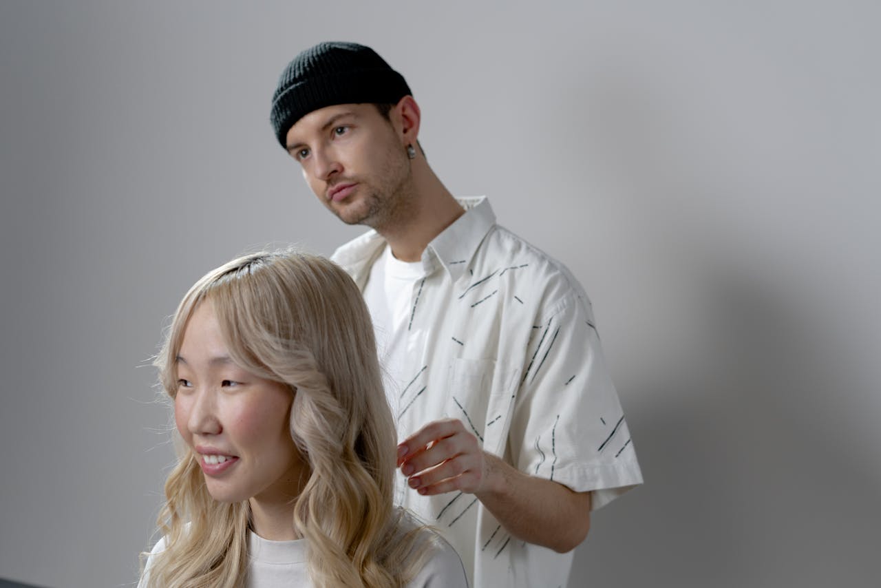 A hairstylist creating a fashionable look in a contemporary salon setting with attentive focus.